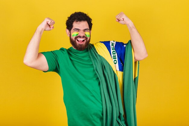 Homme de race blanche avec barbe fan de football brésilien du brésil célébrant et criant bruyamment victoire