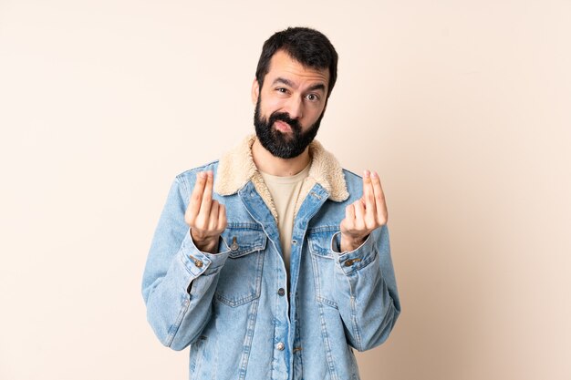 Homme de race blanche avec barbe sur fond isolé faisant le geste de l'argent mais est ruiné