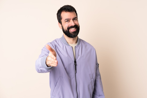 Homme de race blanche avec barbe portant une veste sur des mains tremblantes isolées pour fermer une bonne affaire