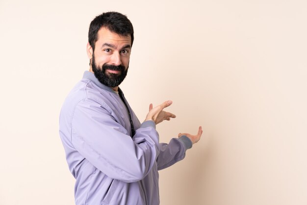 Homme de race blanche avec barbe portant une veste sur le mur, étendant les mains sur le côté