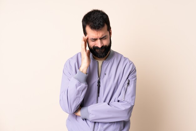 Homme de race blanche avec barbe portant une veste sur le mur avec des maux de tête