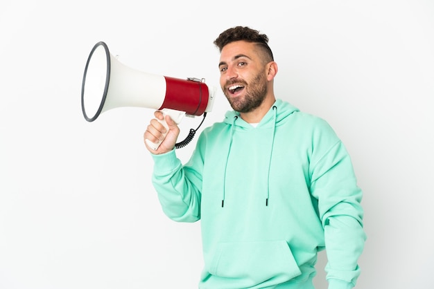 Homme de race blanche isolé sur fond blanc tenant un mégaphone et souriant