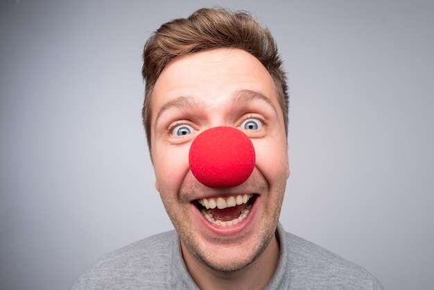 Homme de race blanche avec look fou portant un nez de clown