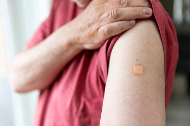 Homme de race blanche avec un plâtre sur le bras après une injection de vaccination