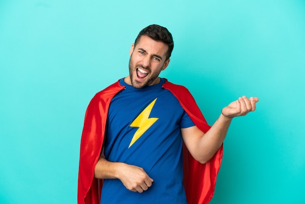 Homme de race blanche de super héros isolé sur fond bleu faisant un geste de guitare