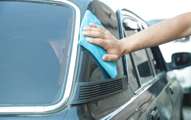 Homme de race blanche avec une voiture de nettoyage en tissu.