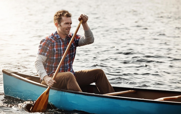Photo homme et rame sur la rivière pour les vacances d'aventure et les sports nautiques dans la nature lac de vacances et camp de survie pour les hommes défi et rame à la campagne pour les compétences en bateau