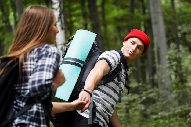 Homme randonneur guidant la femme dans le concept de voyage en forêt