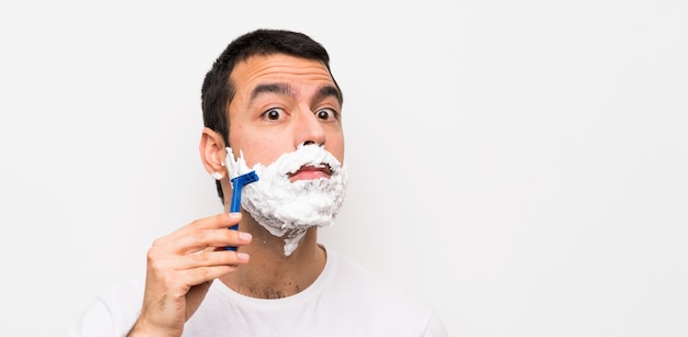 Homme rasant sa barbe blanche isolée