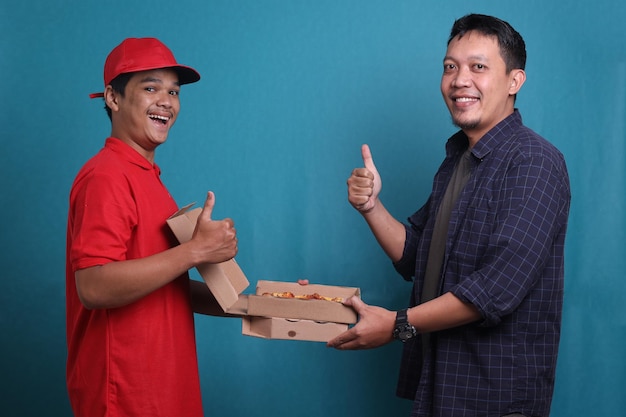 Homme recevant des boîtes de pizza du livreur, tous deux souriant et levant les pouces