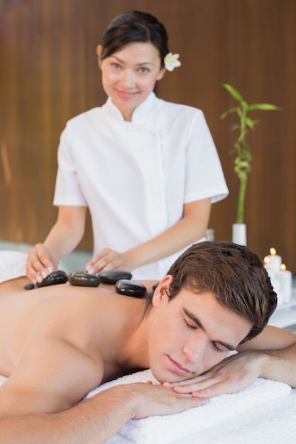 Homme recevant un massage aux pierres au centre de spa