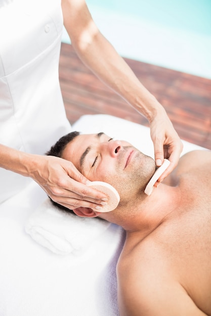 Homme recevant un massage du visage d&#39;un masseur au spa