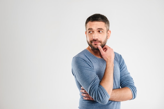 Homme réfléchi isolé sur mur blanc