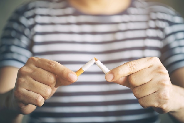 Homme refusant le concept de cigarettes pour arrêter de fumer et fond sombre de mode de vie sain.