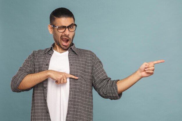 Homme regardant la caméra et pointant et montre un fond sur fond