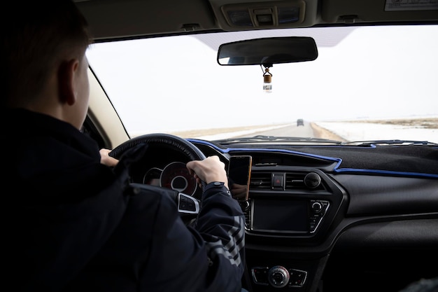 Homme regardant droit au volant d'une voiture sur la route