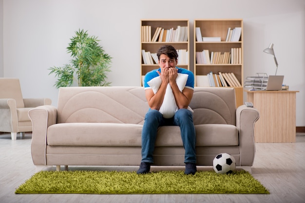 Homme regardant le football à la maison