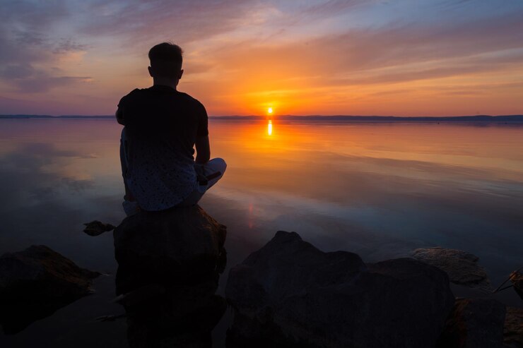 Photo un homme regardant la mer contre le ciel au coucher du soleil