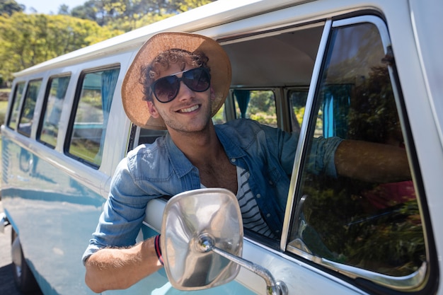 Homme regardant par la fenêtre tout en conduisant un camping-car