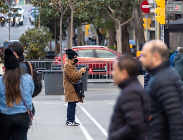 Homme regardant le smartphone au milieu d'une rue fermée à la circulation