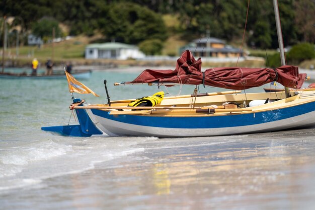 Un homme regarde un bateau en bois sur l'eau au festival des bateaux en bois à Hobart, en Tasmanie, en Australie.