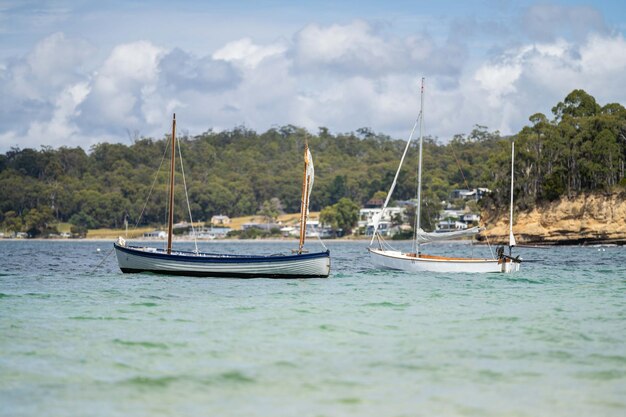 Un homme regarde un bateau en bois sur l'eau au festival des bateaux en bois à Hobart, en Tasmanie, en Australie.