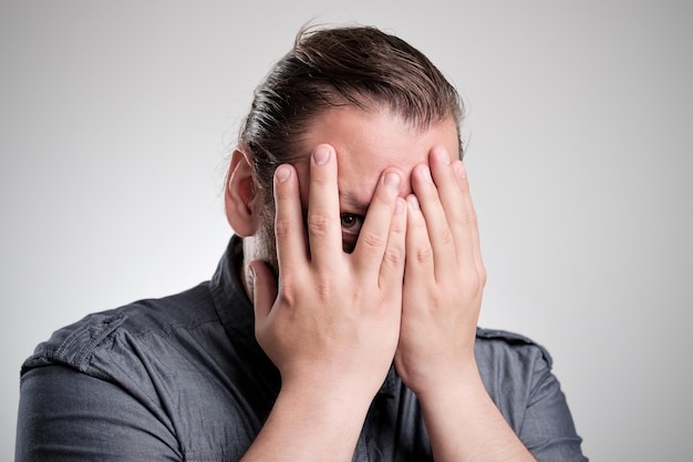 L'homme regarde à travers ses doigts