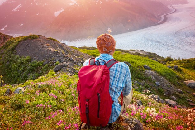 Homme relaxant dans les montagnes au lever du soleil