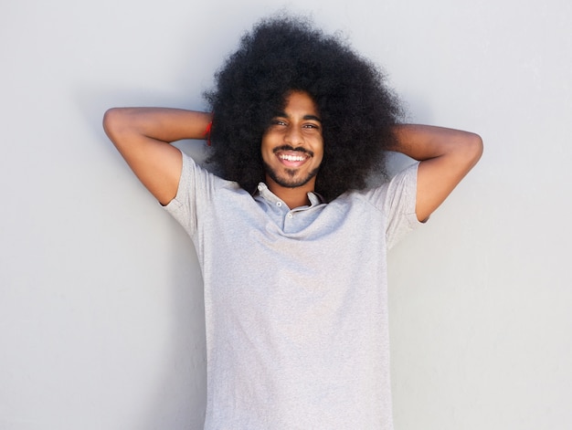 Homme relaxant souriant avec les mains derrière la tête