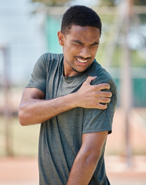 Homme de remise en forme et douleur à l'épaule par le coureur après l'entraînement physique et la course matinale en ville sur fond flou Blessure au bras sport et athlétique souffrant d'arthrite musculaire ou de détresse cardio