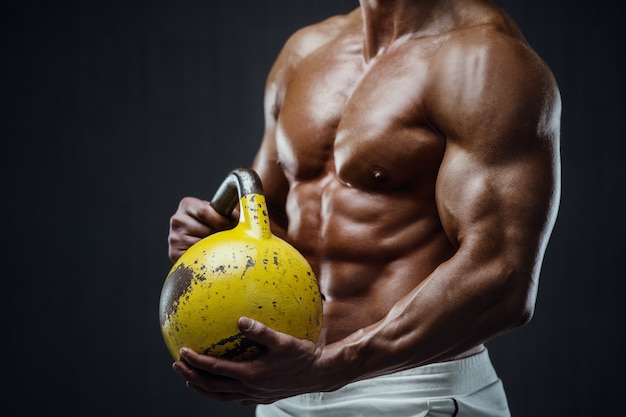 Homme de remise en forme de pompage des muscles avec kettlebell