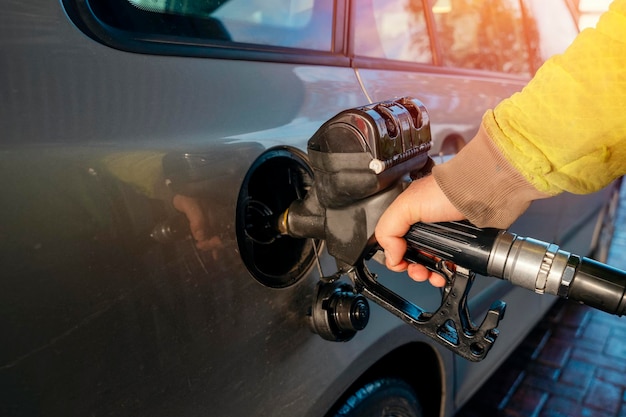 homme remplissant le réservoir de carburant de la voiture avec du carburant diesel à la station-service de près alors que le coût du carburant augmente