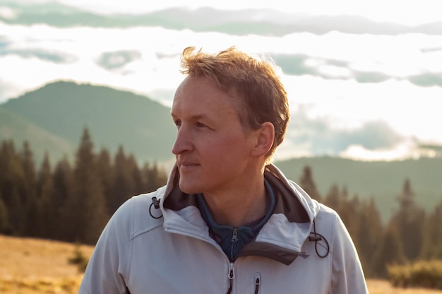 un homme rencontre à l'aube le soleil sur fond de montagnes et de forêts paysage tourisme trav