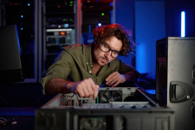 Homme réparant l'unité de système informatique dans le centre de service moderne