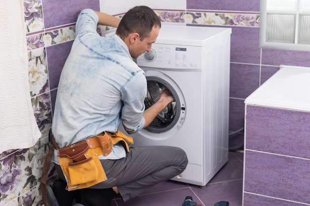 l'homme répare une machine à laver.