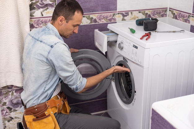 l'homme répare une machine à laver.