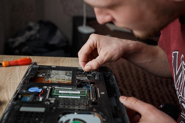 L'homme répare l'ordinateur portable par lui-même réparation d'ordinateur