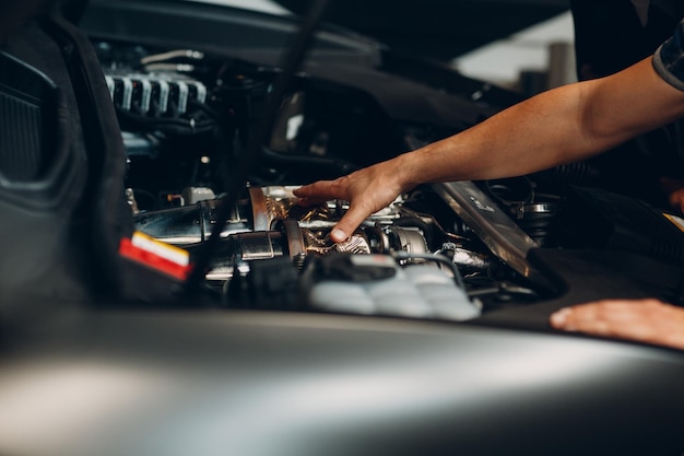 Un homme répare une voiture dans un atelier de réparation automobile