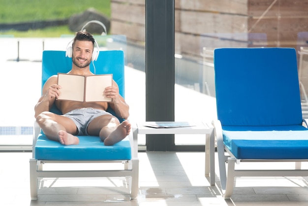 Homme reposant sur une chaise longue et écoutant de la musique