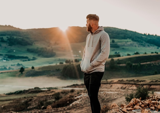 Photo l'homme reste au sommet de la montagne après l'entraînement. concept de motivation