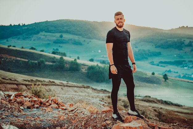 L'homme reste au sommet de la montagne après l'entraînement. Concept de motivation