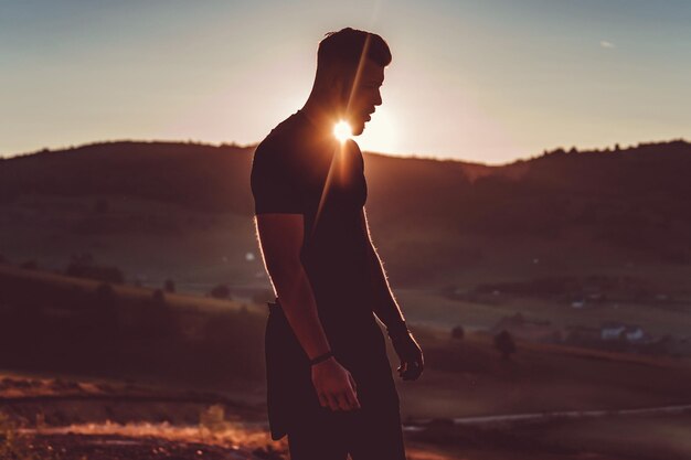 L'homme reste au sommet de la montagne après l'entraînement. Concept de motivation