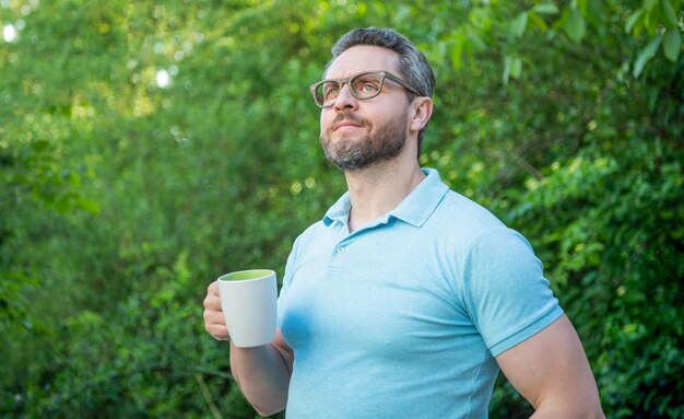 Homme rêveur savoure un café le matin homme savoure un café en plein air photo d'un homme savoure un café homme savoure un café