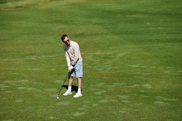 Homme riche jouant au golf sur un terrain vert au soleil