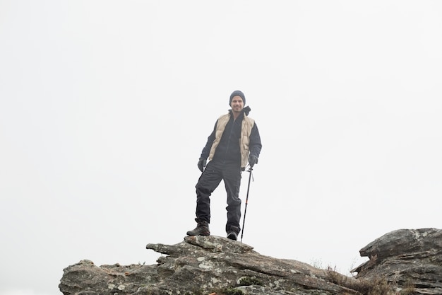 Homme sur le rocher en admirant la vue après une randonnée