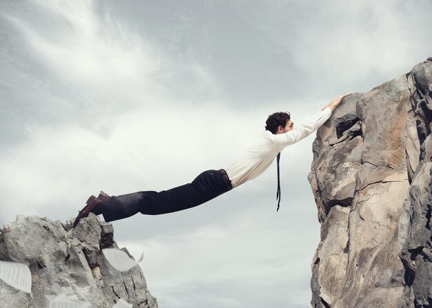 Photo un homme sur un rocher contre le ciel