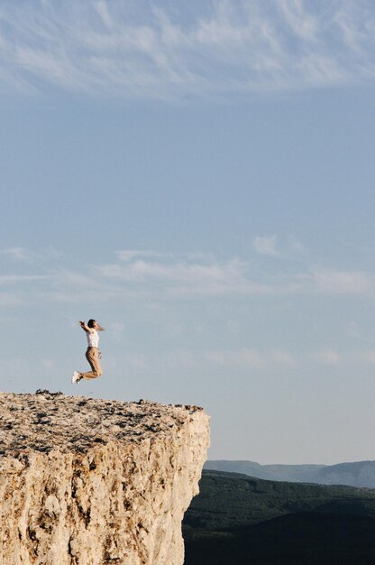 Photo un homme sur un rocher contre le ciel