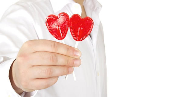 Un homme romantique donne un cadeau de sucettes en forme de cœur le jour de la Saint-Valentin