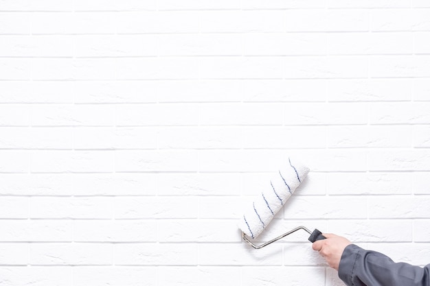 Un homme avec un rouleau peint le mur