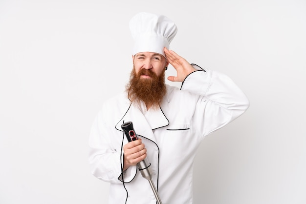 Homme rousse à l'aide d'un mélangeur à main sur un mur blanc isolé, mécontent et frustré par quelque chose. Expression faciale négative